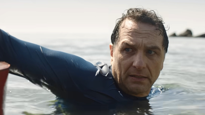 A terrified man clings to a buoy in the ocean