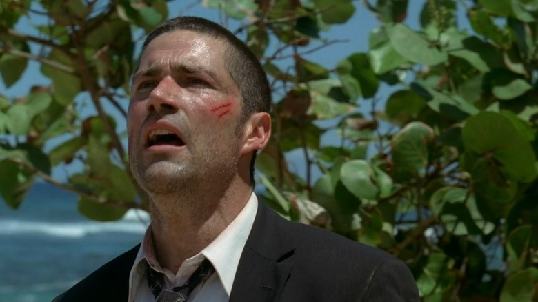 A scuffed up Jack Shephard (Matthew Fox) stares distraught next to a tree in Lost