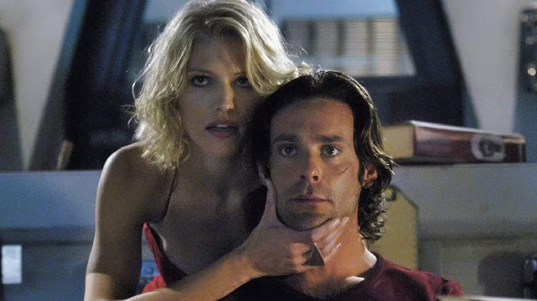Tricia Helfer as Number Six holding the chin of James Callis as Dr. Baltar in Battlestar Galactica