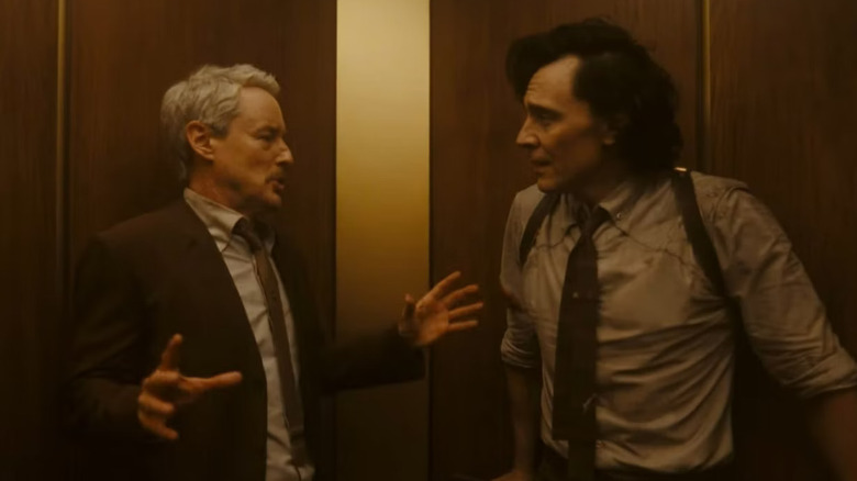 Owen Wilson as Mobius looking startled at Tom Hiddleston as Loki in an elevator in Loki