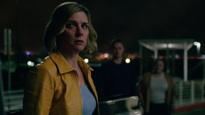 Rhea Seehorn as Carol looking scared while people stare at her in Pluribus