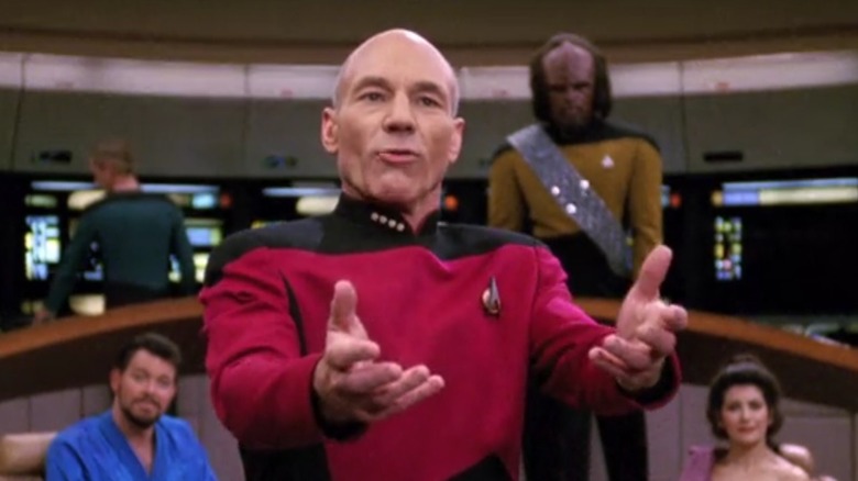 Patrick Stewart as Picard holding out his hands in front of Jonathan Frakes as Riker, Michael Dorn as Worf, and Marina Sirtis as Deanna in Star Trek The Next Generation