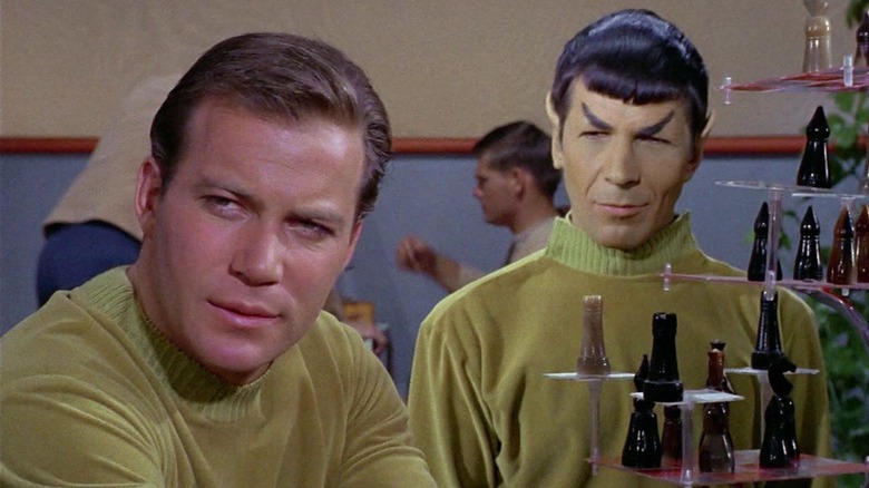 William Shatner and Leonard Nimoy as Kirk and Spock sitting and smiling in green sweaters in Star Trek