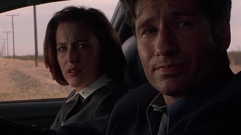 Gillian Anderson as Scully sitting next to David Duchovny as Mulder in a car in The X-Files