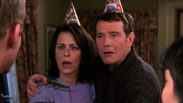 Bryan Cranston's Hal and Jane Kaczmarek's Lois looking surprised in birthday party hats