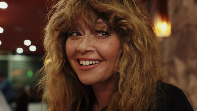 Charlie Cale (Natasha Lyonne) smiles with tears in her eyes in Poker Face