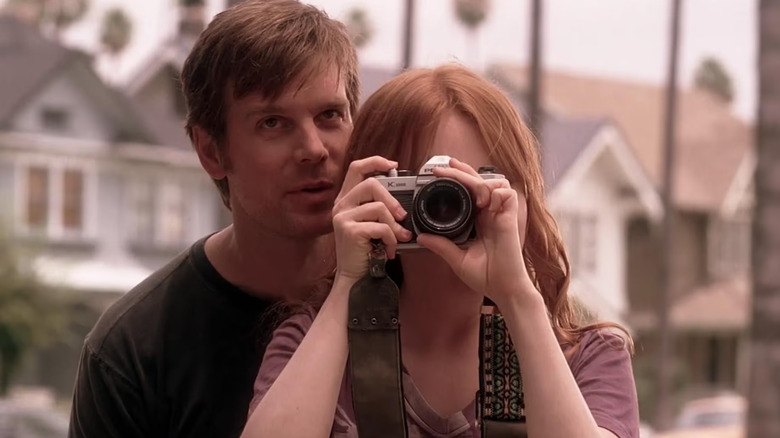 Nate Fisher, standing behind Claire Fisher as she takes a picture with a camera in Six Feet Under.