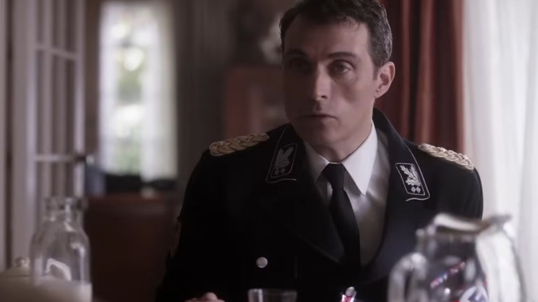 A military officer sits at a table.