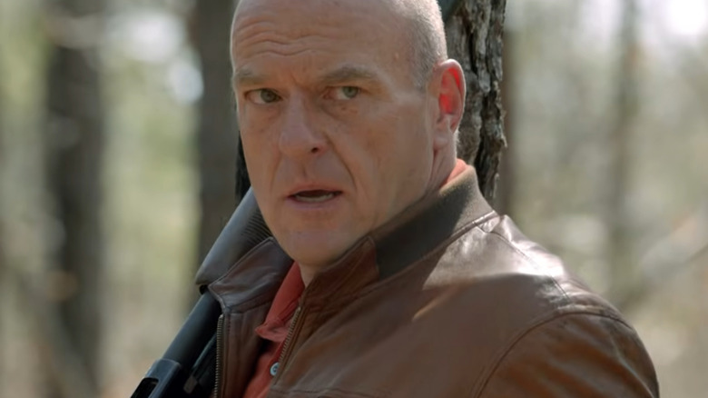 A man stands in the woods looking scared.