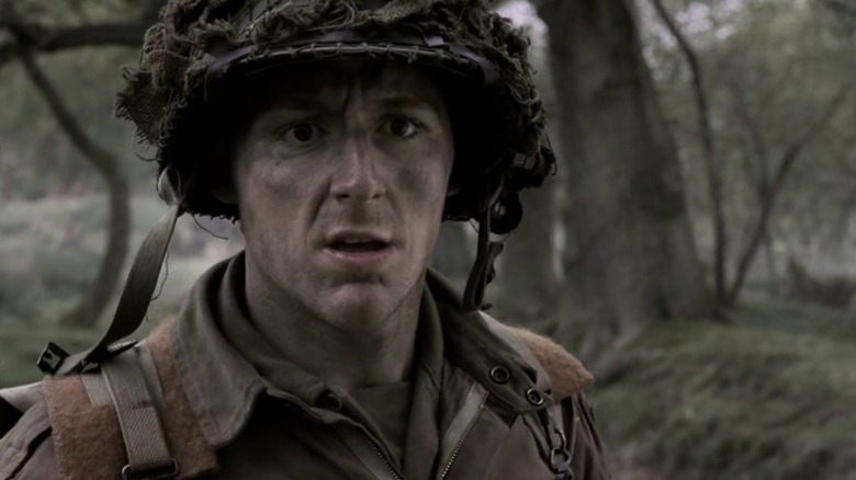 Donald Malarkey standing near trees with a worried expression on Band of Brothers S1E2