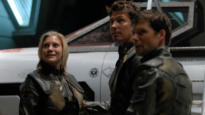Katee Sackhoff as Starbuck standing next to Tahmoh Penikett as Karl and Jamie Bamber as Apollo in Battlestar Galactica
