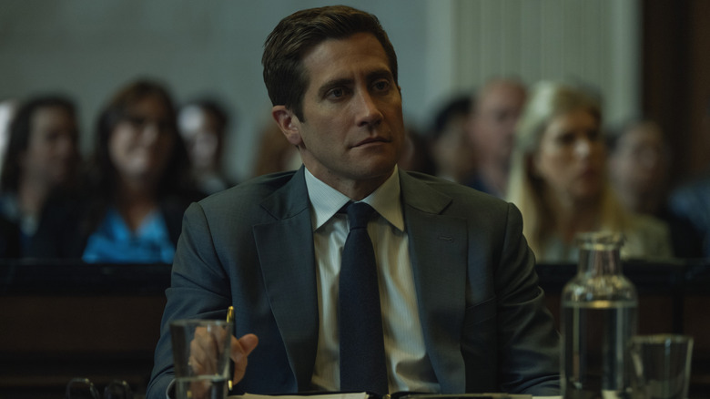 Rusty sitting in a courtroom, looking on