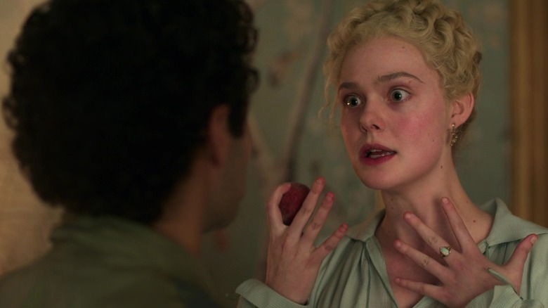 Catherine talking and looking very animated while holding a fruit