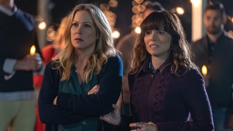 Jen Harding standing at a vigil with Judy Hale as they look concerned in Dead to Me