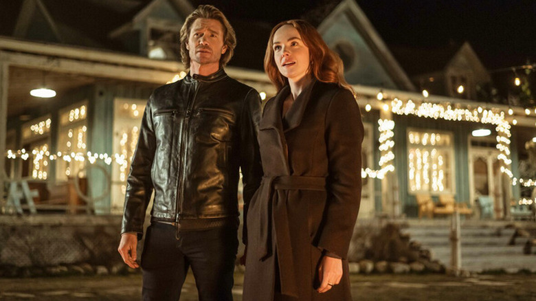 Cal Jones (Chad Michael Murray) and Maggie Sullivan (Morgan Kohan) stand by a house with Christmas lights on in Sullivan's Crossing