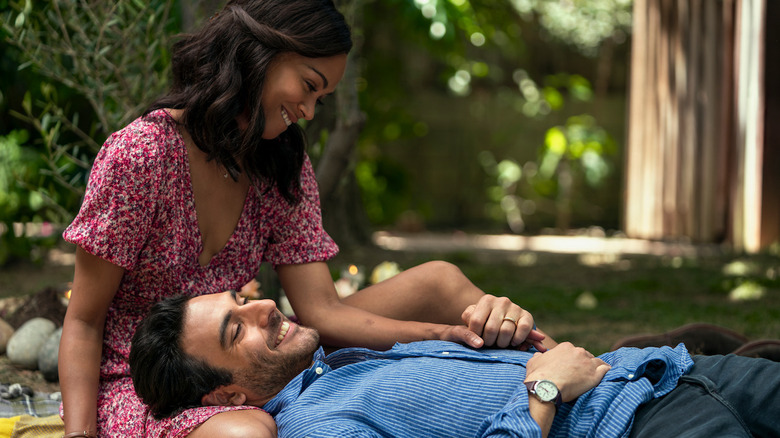 Amy (Zoe Saldaña) smiles while cradling the head of Lino (Eugenio Mastrandrea) in her lap in From Scratch