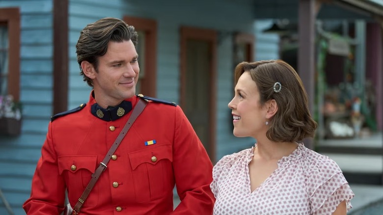 Jack Thornton (Daniel Lissing), in his Mountie uniform, smiles as he walks with Elizabeth Thatcher (Erin Krakow) in When Calls the Heart