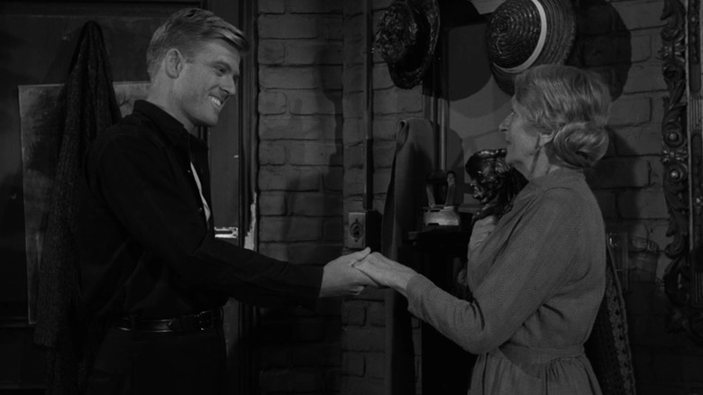 Harold Beldon (Robert Redford) grins while holding the hand of  Wanda Dunn (Gladys Cooper) in The Twilight Zone (1959)