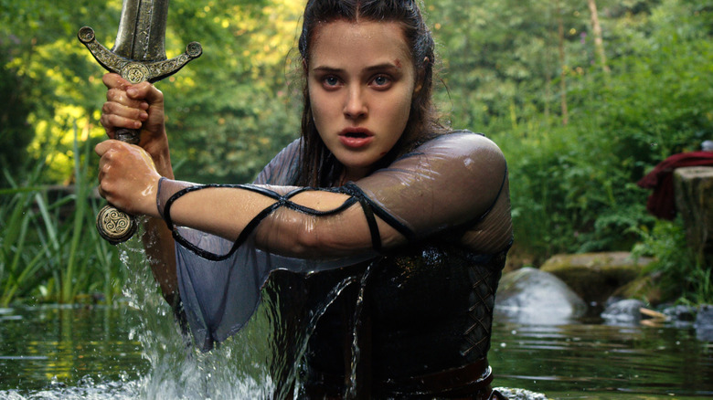 Katherine Langford's Nimue holding a sword waist deep in water on Cursed