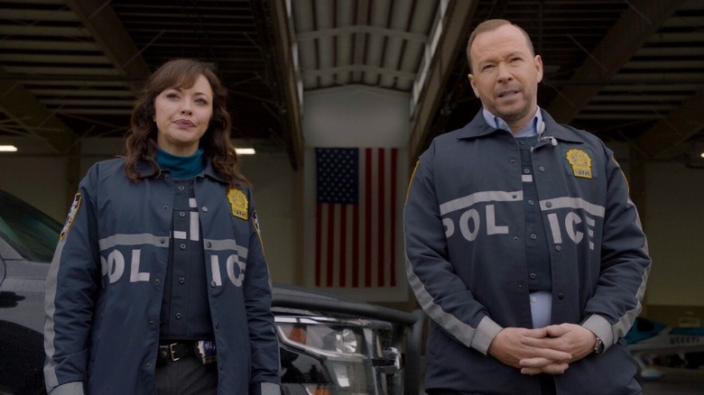 Detective Maria Baez standing next to Detective Danny Reagan in police uniform jackets