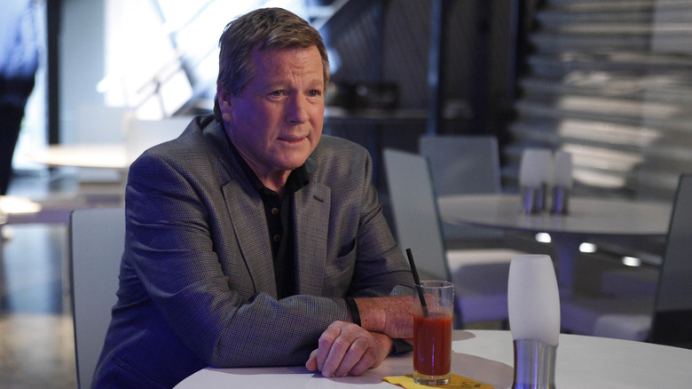 Max Keenan (Ryan O'Neal) sitting at table with bloody mary