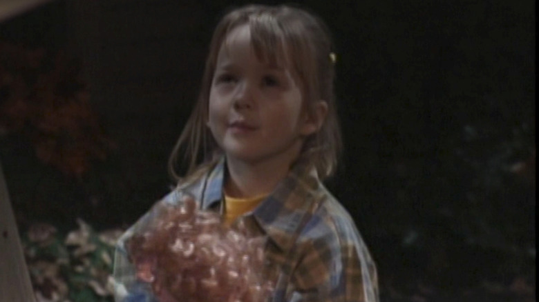 Lily Nicksay as Morgan Matthews outside holding a doll in the pilot of Boy Meets World