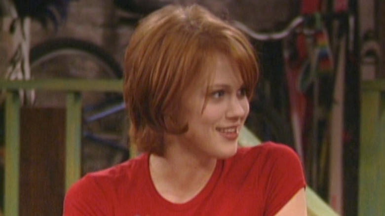 Maitland Ward as Rachel McGuire weaing a red shirt and smiling in Seaosn 6 of Boy Meets World