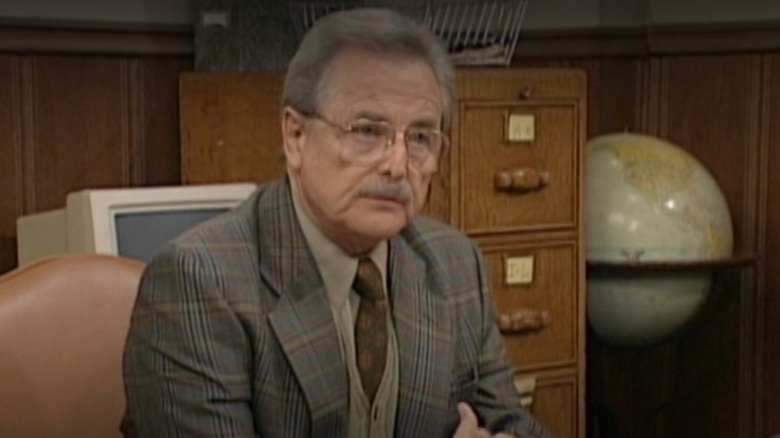 William Daniels as Mr. Feeny sitting at his desk in Season 4 of Boy Meets World