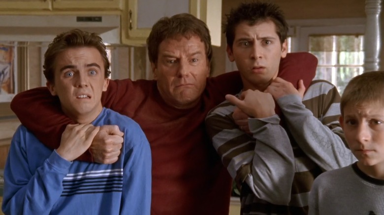 A nervous Hal grabs hold of Malcolm and Reese, with Dewey next to them, on Malcolm in the Middle.