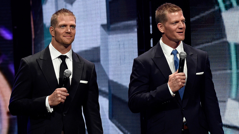 Jason and David Benham on stage in suits holding microphones