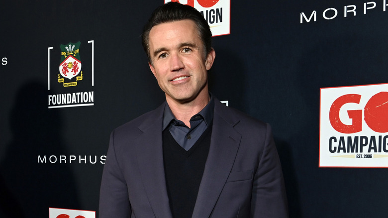 Rob Mac wears a suit and poses for a red carpet gallery photo