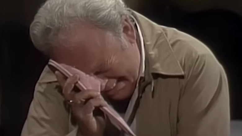 Archie Bunker mourns the death of his wife, Edith, crying into her slipper