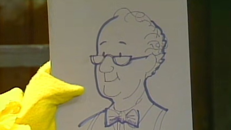 Big Bird holding up his portrait of Mr. Hooper