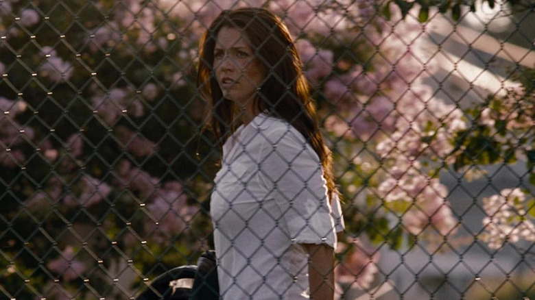 Lacy walking behind a chain link fence on The Expendables