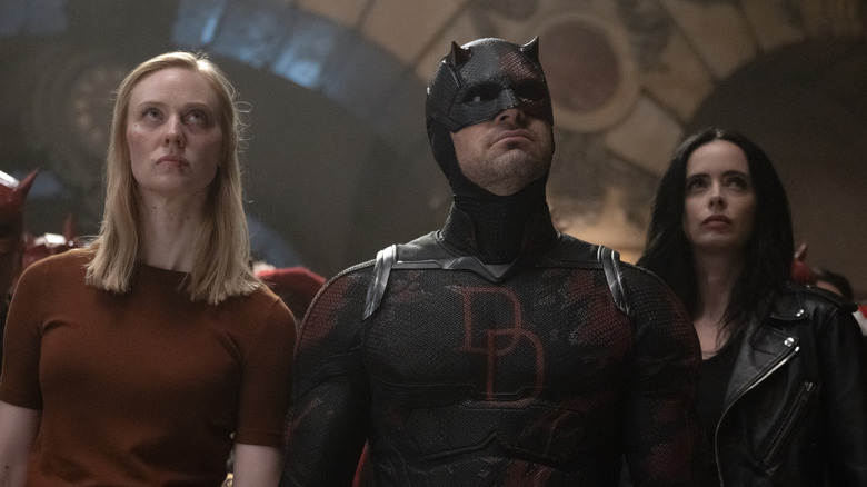 Karen Page, Daredevil, and Jessica Jones standing together while looking up.