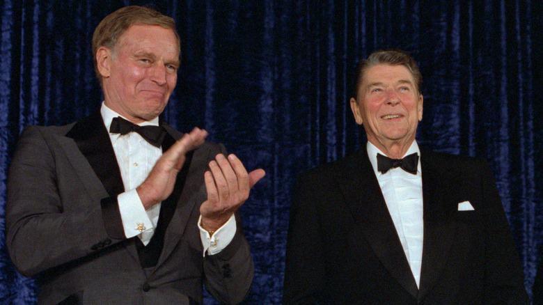 Charlton Heston and Ronald Reagan wearing black tie on stage