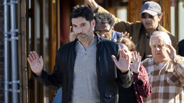 Colin Glass leaves a building with his hands up