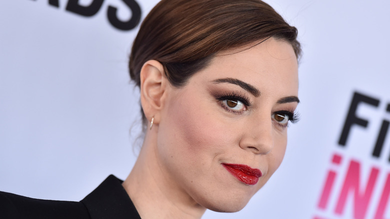 Aubrey Plaza smiling and wearing red lipstick