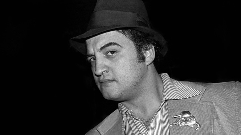 Old image of John Belushi raising an eyebrow at the camera