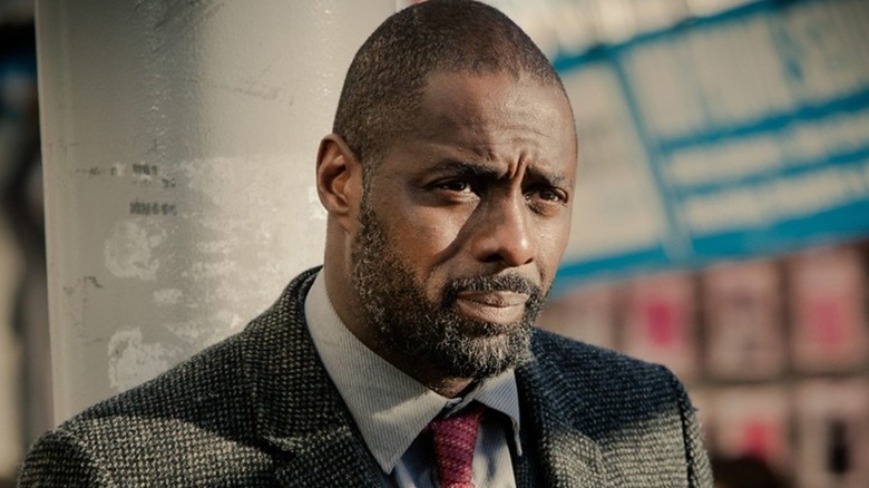 John Luther (Idris Elba) stands against a column in Luther