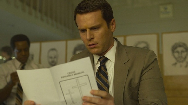 Holden Ford (Jonathan Groff) examines a cross assembly manual in Mindhunter