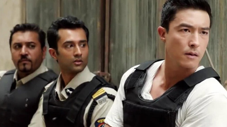 Agent Matt Simmons in front of two Indian officers, all wearing bulletproof vests