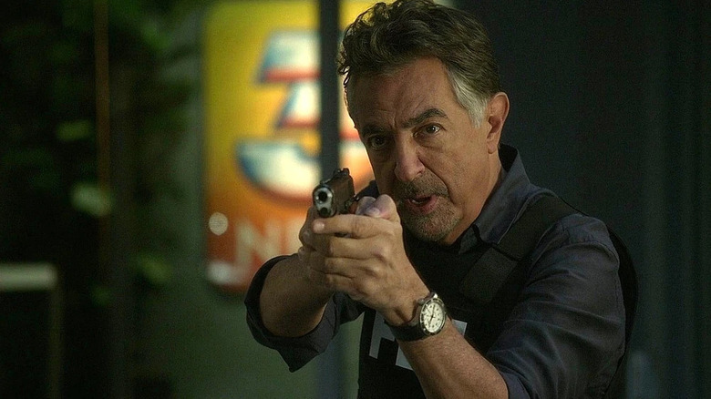 Joe Mantegna as David Rossi holding a gun