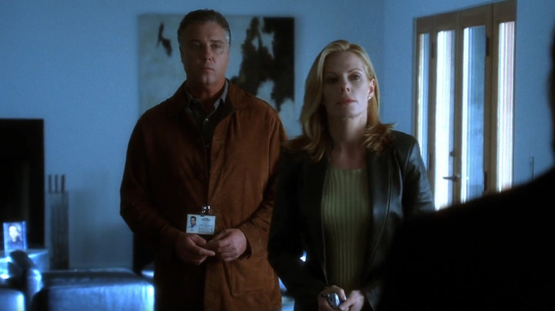 Gil Grissom and Catherine Willows standing in an apartment looking at a suspect