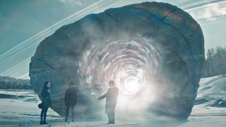 Star Trek: Discovery'de karlı bir manzara üzerinde devasa bir kayanın ve parlayan portalın önünde duran üç kişi