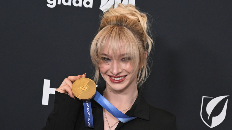 Amber Glenn holding gold medal on red carpet