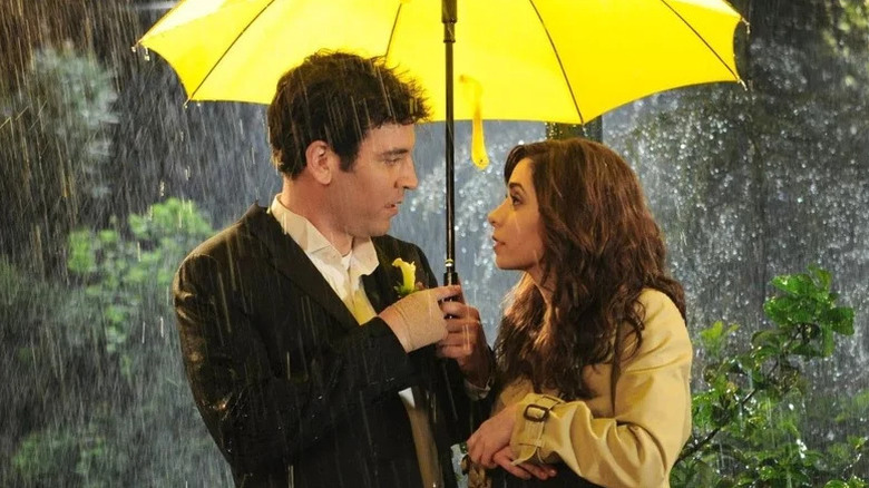 Ted standing under yellow umbrella next to Tracy in How I Met Your Mother
