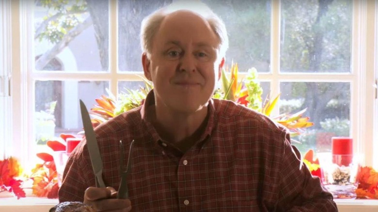 John Lithgow as Arthur Mitchell, smiling with a knife in Dexter.
