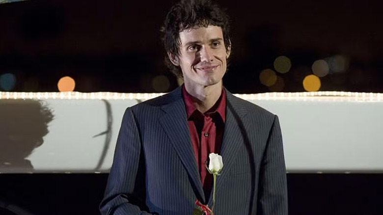 Christian Camargo as Brian Moser, smiling holding a rose in Dexter.