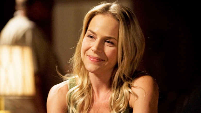 Julie Benz as Rita Bennett, smiling at the table in Dexter.